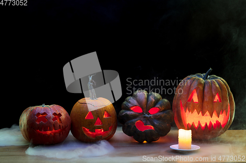 Image of Halloween pumpkin head jack lantern with scary evil faces and candles