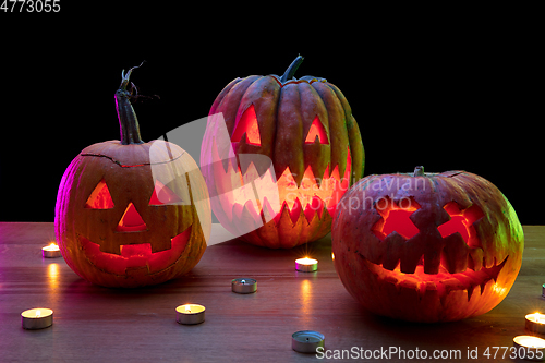 Image of Halloween pumpkin head jack lantern with scary evil faces and candles