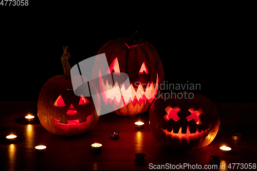 Image of Halloween pumpkin head jack lantern with scary evil faces and candles