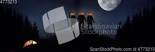 Image of Halloween theme: scary maniacs with pumpkin head in dark forest