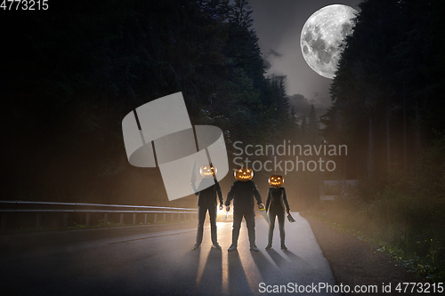 Image of Halloween theme: scary maniacs with pumpkin head on the road