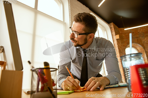 Image of A young businessman moving in office, getting new work place