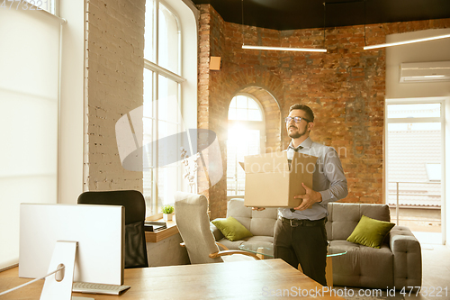Image of A young businessman moving in office, getting new work place