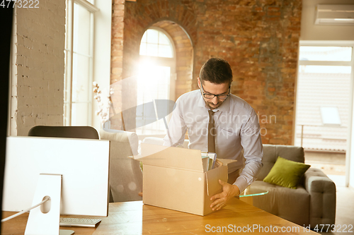 Image of A young businessman moving in office, getting new work place