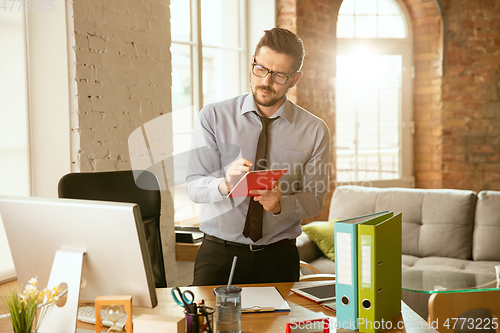 Image of A young businessman moving in office, getting new work place