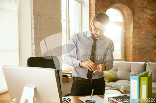 Image of A young businessman moving in office, getting new work place