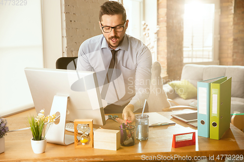 Image of A young businessman moving in office, getting new work place