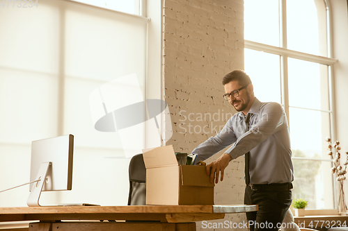 Image of A young businessman moving in office, getting new work place