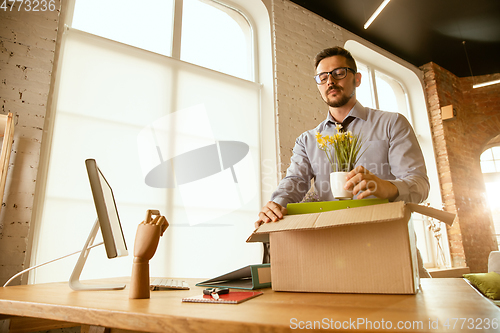 Image of A young businessman moving in office, getting new work place