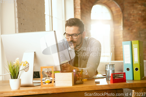 Image of A young businessman moving in office, getting new work place