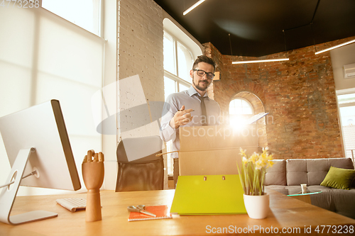 Image of A young businessman moving in office, getting new work place