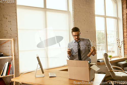 Image of A young businessman moving in office, getting new work place