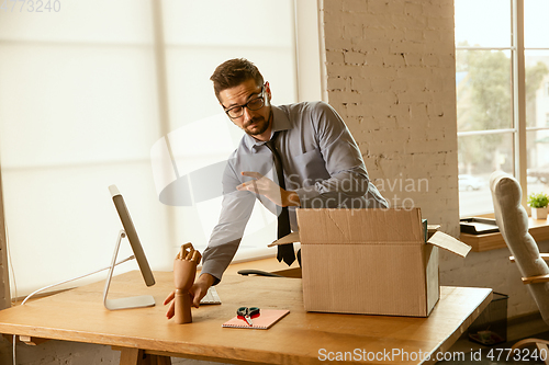 Image of A young businessman moving in office, getting new work place