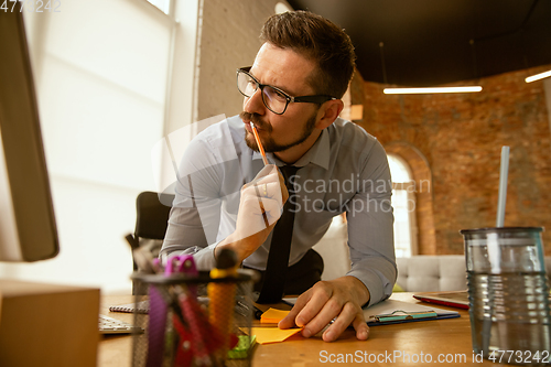 Image of A young businessman moving in office, getting new work place