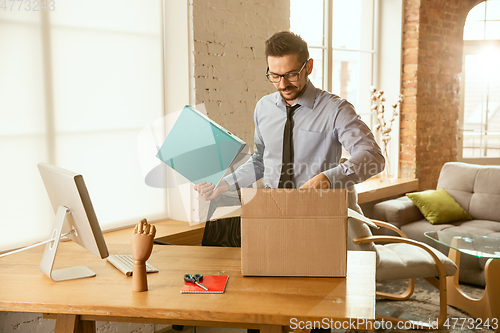 Image of A young businessman moving in office, getting new work place