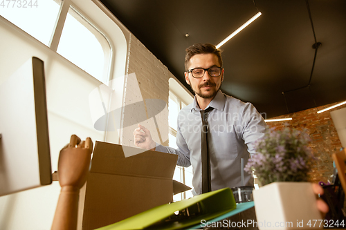 Image of A young businessman moving in office, getting new work place