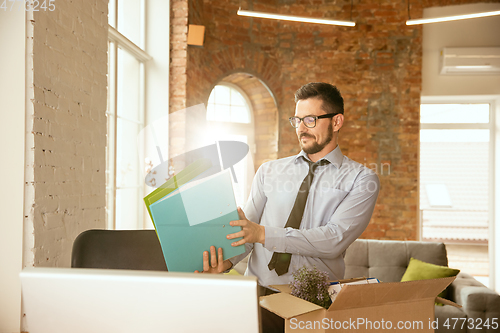 Image of A young businessman moving in office, getting new work place