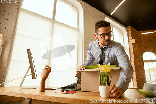 Image of A young businessman moving in office, getting new work place