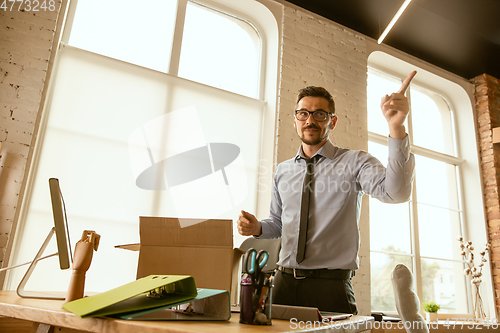 Image of A young businessman moving in office, getting new work place