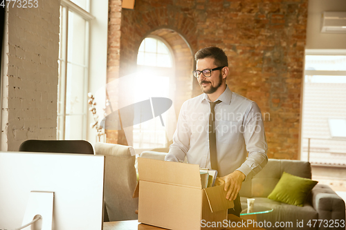 Image of A young businessman moving in office, getting new work place