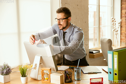 Image of A young businessman moving in office, getting new work place