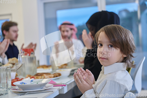 Image of Muslim family making iftar dua to break fasting during Ramadan.