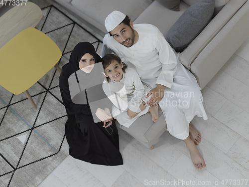 Image of Top view of young arabian muslim family wearing traditional clothes