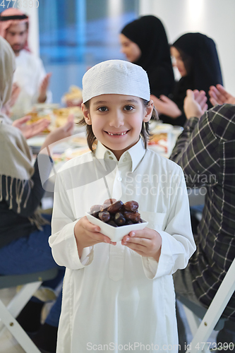 Image of Arabian kid in the traditional clothes during iftar