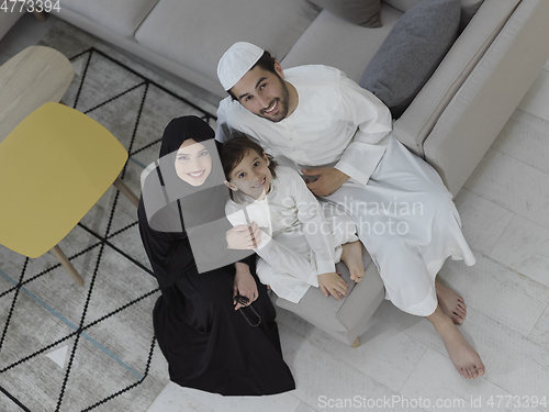 Image of Top view of young arabian muslim family wearing traditional clothes