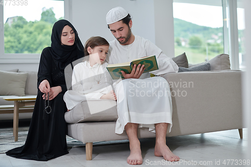 Image of Young muslim family reading Quran during Ramadan