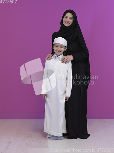 Image of young arabian mother and son wearing traditional clothes
