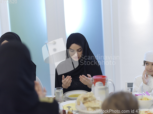 Image of Muslim family making iftar dua to break fasting during Ramadan