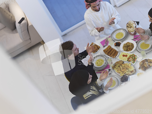 Image of Top view of Muslim family making iftar dua to break fasting during Ramadan