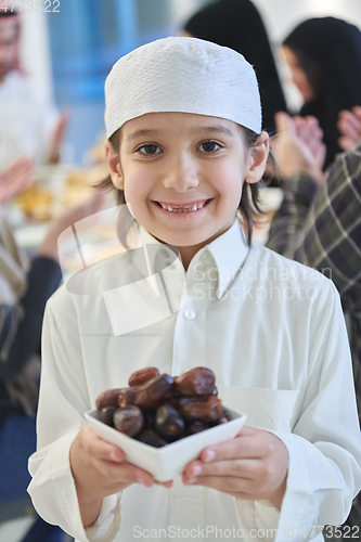 Image of Arabian kid in the traditional clothes during iftar