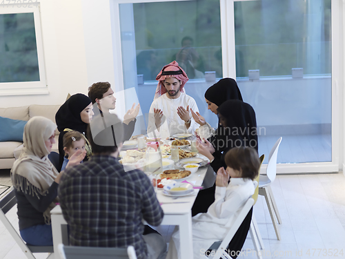 Image of Muslim family making iftar dua to break fasting during Ramadan