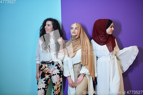 Image of Young muslim women posing on purple and blue background