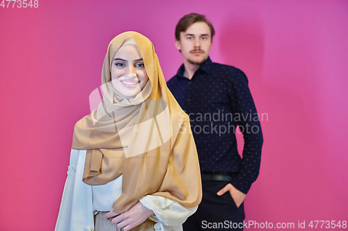 Image of Portrait of happy young muslim couple standing isolated on pink background