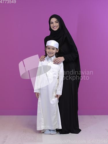 Image of young arabian mother and son wearing traditional clothes