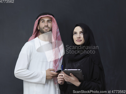 Image of Young muslim business couple using technology devices