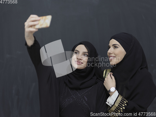 Image of Portrait of Arab women wearing traditional clothes or abaya taking selfie