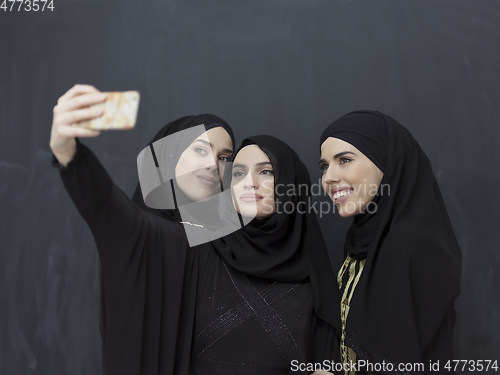 Image of Portrait of Arab women wearing traditional clothes or abaya taking selfie