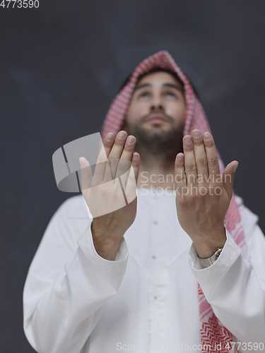 Image of Arab man in traditional clothes praying to God or making dua