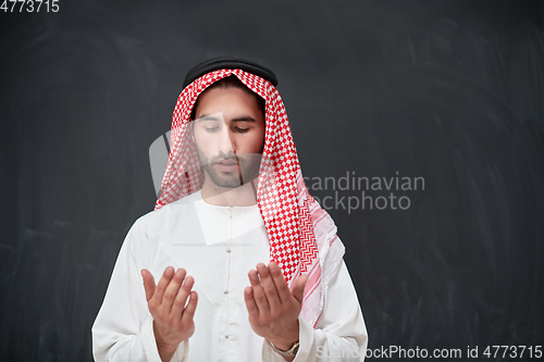 Image of Arab man in traditional clothes praying to God or making dua