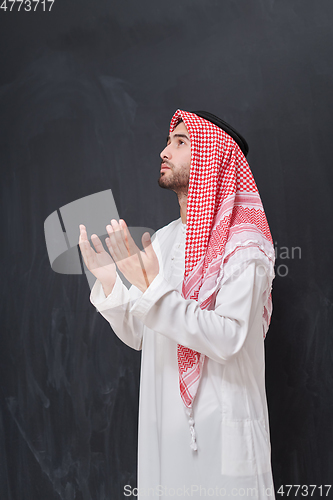 Image of Arab man in traditional clothes praying to God or making dua