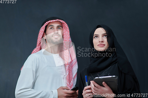 Image of Young muslim business couple using technology devices