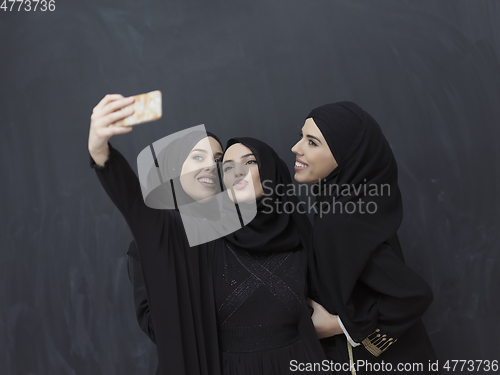 Image of Portrait of Arab women wearing traditional clothes or abaya taking selfie