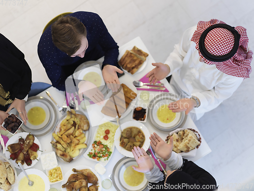 Image of Top view of Muslim family making iftar dua to break fasting during Ramadan