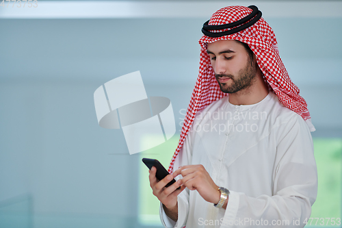 Image of Portrait of young muslim businessman using mobile phone