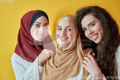 Image of Young muslim women posing on yellow background