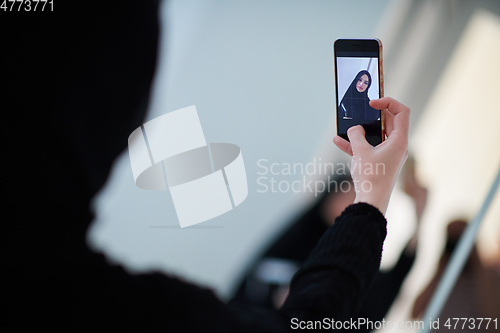 Image of Young muslim businesswoman in traditional clothes or abaya taking selfie.